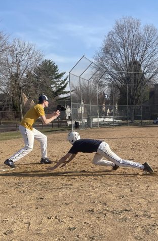 SLIDING SUCCESS. Eighth grader, Charlie Zakaib dives for the base before his teammate catches the baseball. This was Charlie’s third slide and his pants were completely covered in the dirt.