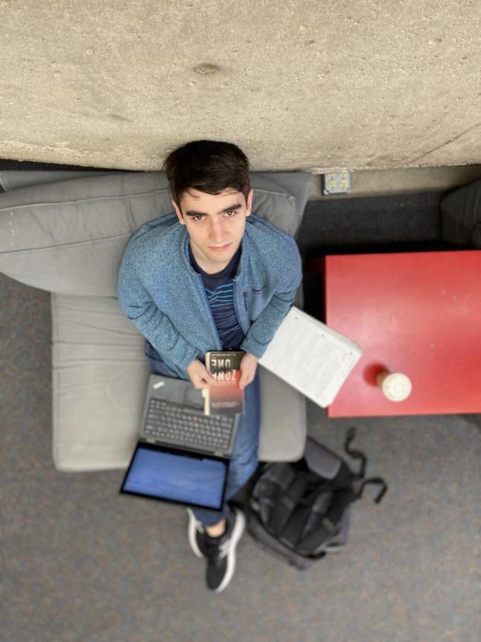 PRIVATE SPACE. Senior Colin Will frequently sits in the lower library near the concrete stairs during his free time. “I like this spot because no one can see what I’m working on,” Will said.