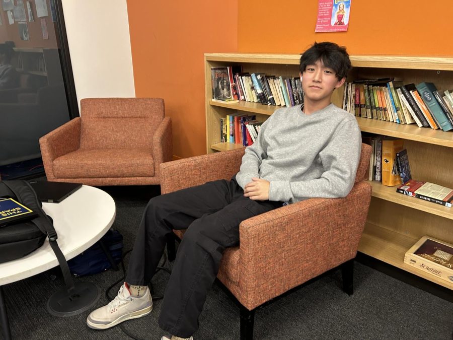 SILENT SOCIALIZING. Senior Andrew Bai appreciates the calm nature of the English hallway commons. Ive kind of always been hanging out here with my friends and its quieter than Schilling, he said.