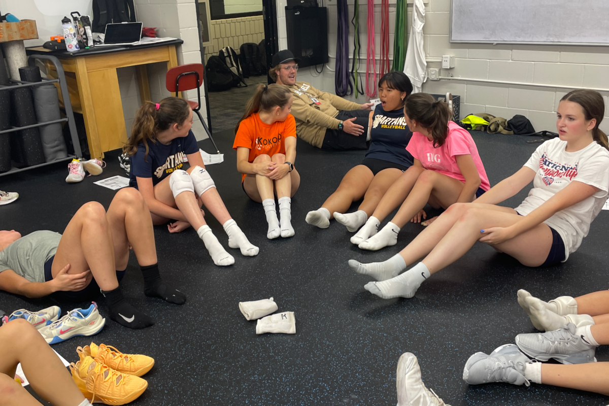 VOLLEYBALL “POWERS” UP. The varsity volleyball team watches a Powerhouse trainer demonstrate a boat hold exercise. “There are many things that can be done to decrease the odds of [injury],” SPA alum and Powerhouse co-owner Jill Lipset said. 