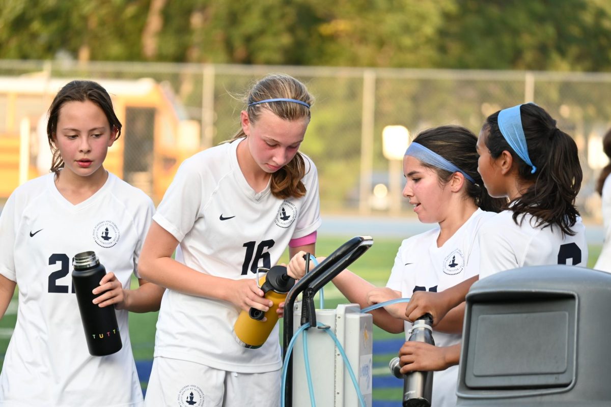 STAYING COOL. Girls junior varsity soccer cools off and stays hydrated after their game against Breck Sept. 5. Boys soccer faced similar struggles with high temperatures in a game against St. Croix Lutheran. “We were all super tired and dehydrated by the second half [of the ... game],” defender Lucas Granja said. 