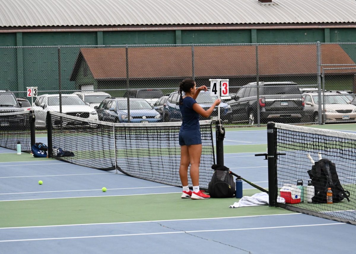 ANOTHER POINT. Captain Audrey Senaratna walks up to the score board to change the Spartan point from 3-3 to 4-3. Senaratna just finished a singles set, and after changing the score, her and her opponent will take a water break and continue.