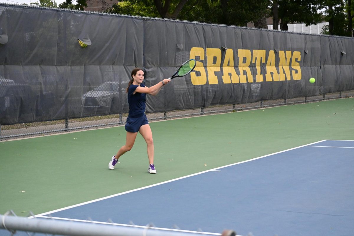 SWISH. Sophomore Nellie Larson throws a backhand stroke as the ball flies towards her. Her opponent  on the other side of the court is preparing to stroke the ball when it whizzes back through the air to them.