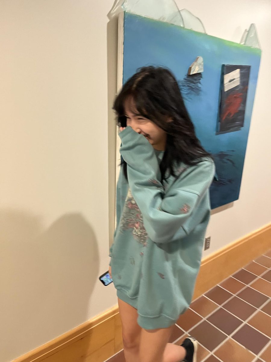 LAUGHING IN THE FACE OF DREAD. Junior June Dalton laughs her way through the beginning of yet another week while wandering through the art wing. “What do you want me to say? This Monday is at least a little better because at least we have less school this week," she said.