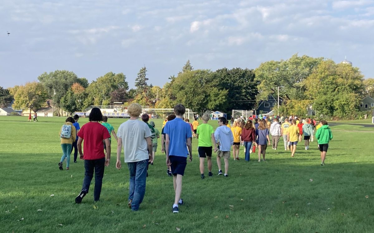 FIRST TIME IN A LONG TIME. Upper school students walk towards the bleachers on Lang Field for the all-school assembly. This was the first joint assembly in 30 years.