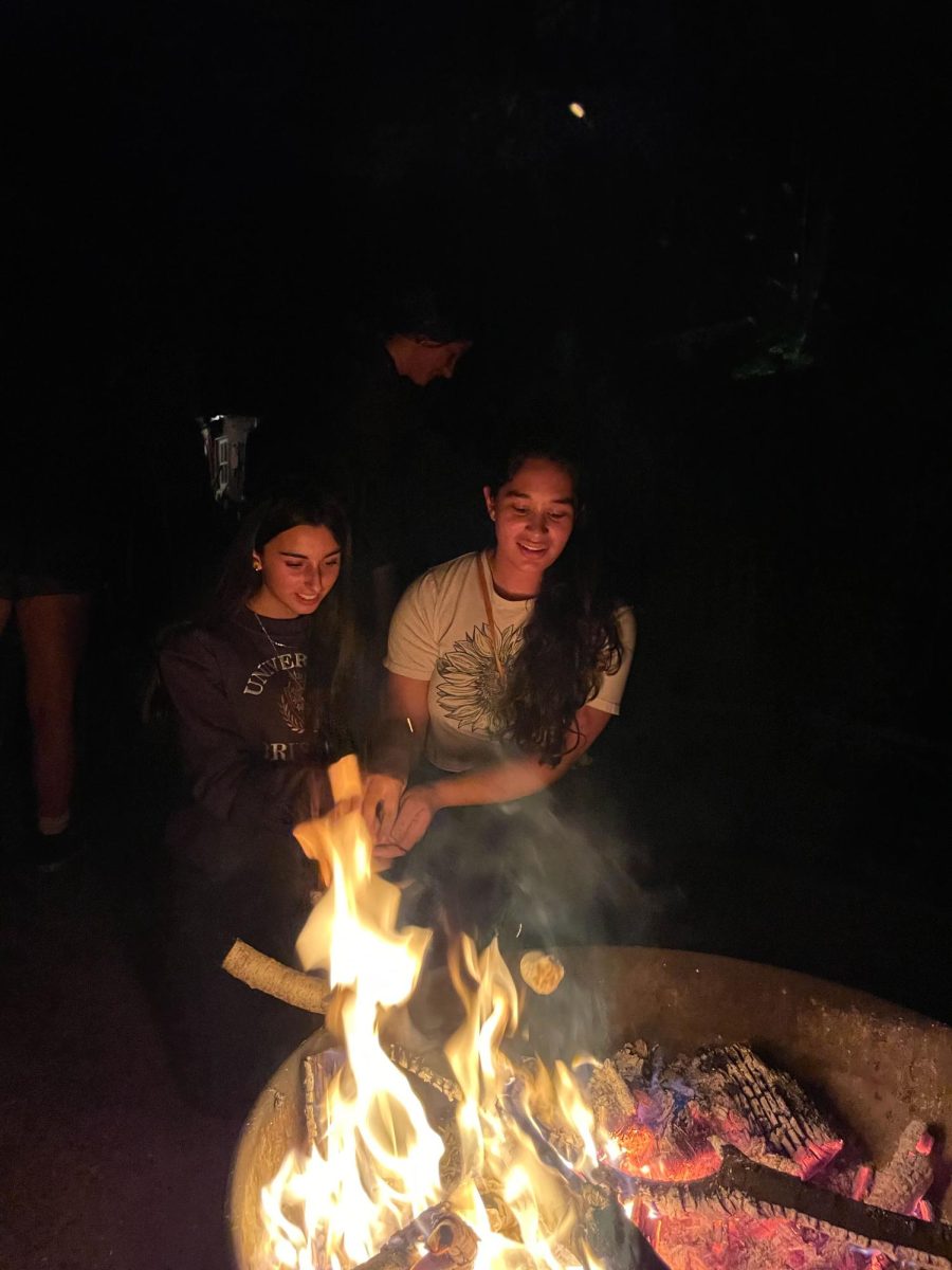 FIRESIDE FUN. Spanish exchange student Irene Salinero and host student Melina Kannankutty roast marshmallows in front of a firepit. 
