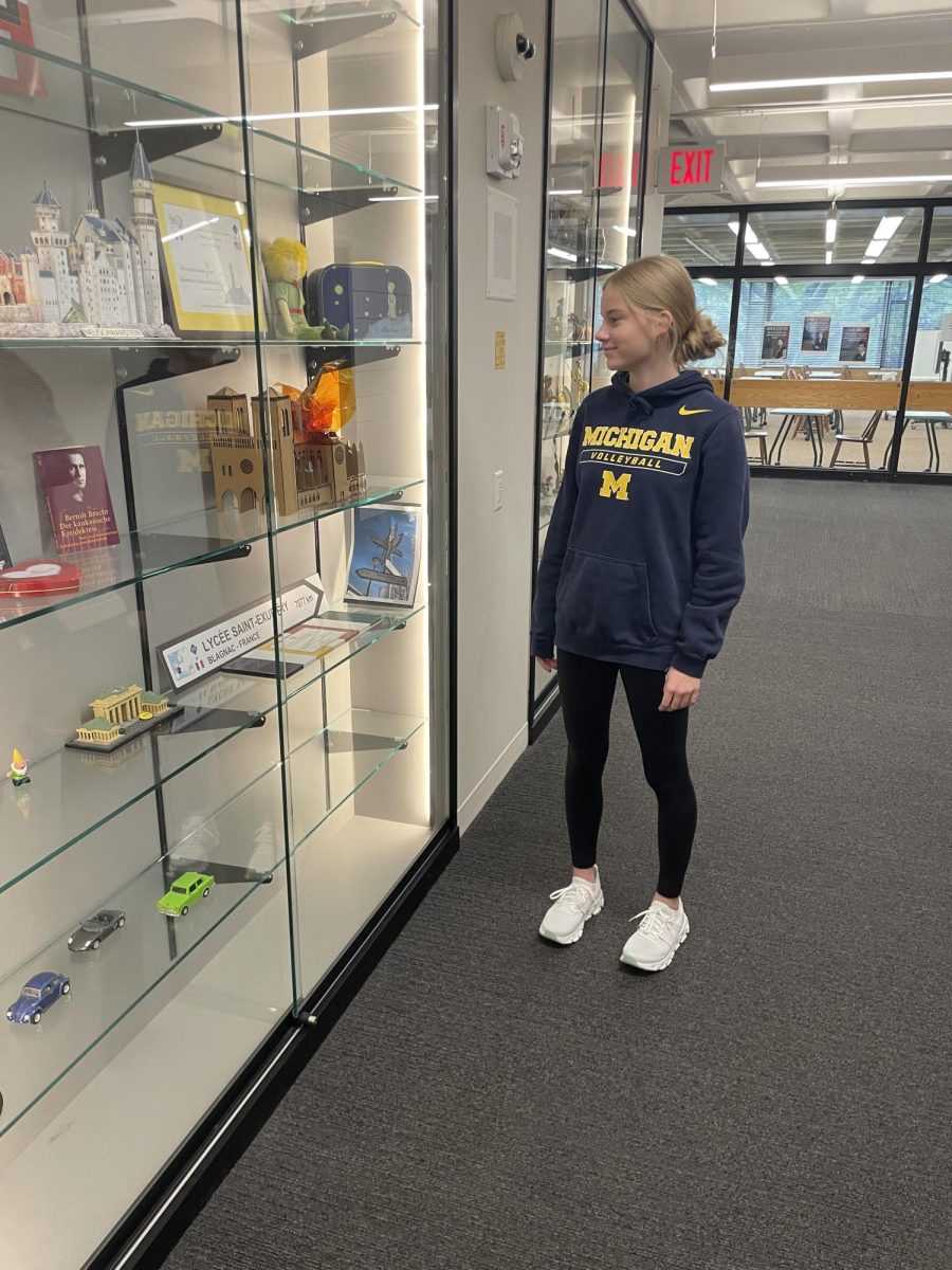 STUDY BREAK. Freshman Norah Evens looks passionately into a local glass case outside her German class during the first period. 