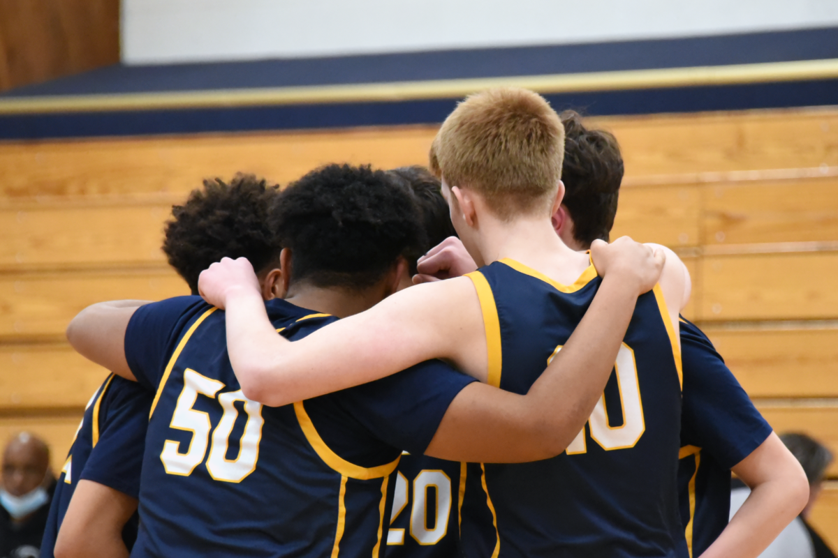TEAM. Boys basketball athletes huddle up in a circle, supoprting one another during a game. This support is one of the many positives the athletic's programs foster. "Athletes and families largely reported that SPA athletics live up to the school mission," Senior Siri Pattison said.