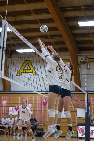 WALL OF STEEL. Junior Madelyn Moser and sophomore Nora McKoy jump up to block a hit. 