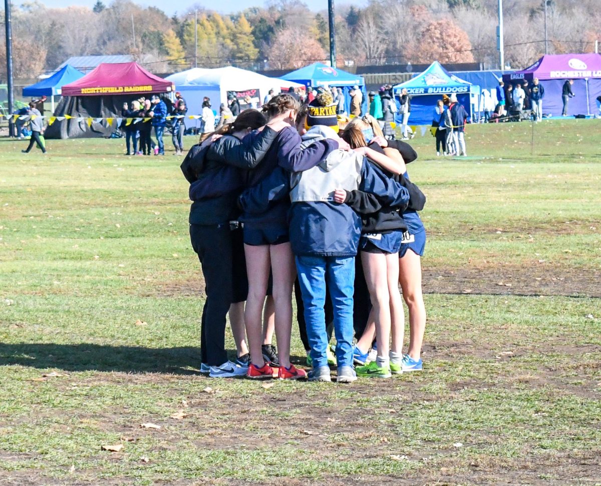 TEAMWORK IS WHAT MAKES THE TEAM WORK. The girls xc team huddles right before the race.