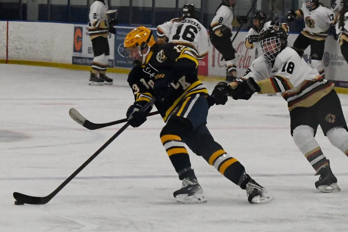 DEFENDING HOME ICE. Forward Ella Berthiaume defends a Breck skater as they move across the ice.