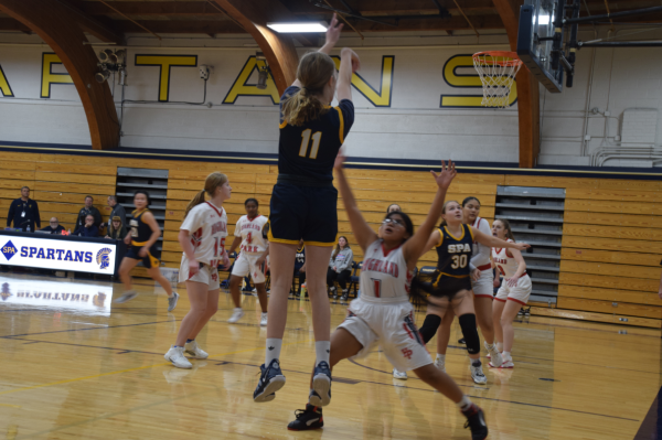 JUMPER.  Eighth-grader Clara Lovelace swishes a three-pointer over the opposing Highland Park player.