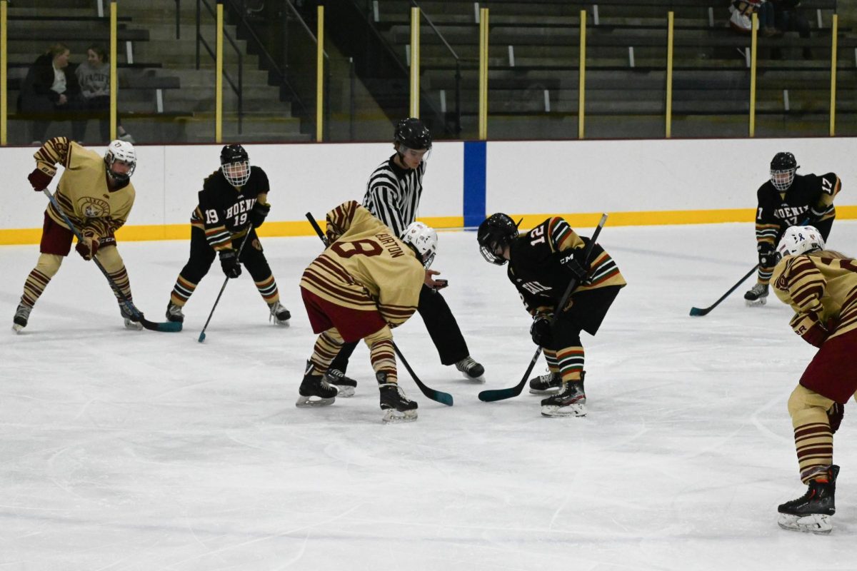 TIME FOR SHOWDOWN. The Cougars and Phoenix's No. 12, Rayna Stecklein from DeLaSalle, stood in the middle of the ice rink to get ready for face off. Tension was high in the air as everyone in the rink waited from the referee to release the puck.