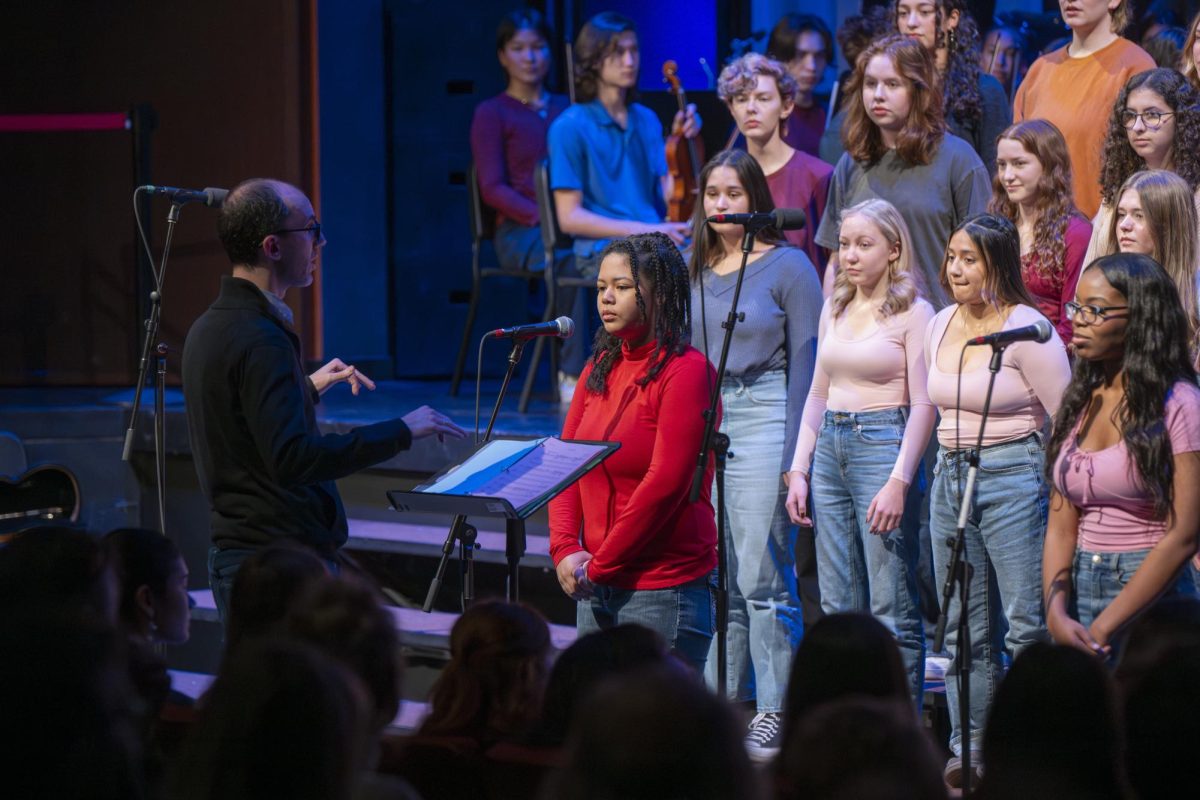 SOLO. The second song the Academy Chorale sang was “All for Us” by Timothy McKenzie. Sophomore Lucille Brooks and senior Millicent Benson made their way through the steps to the mics, waiting for their solos.