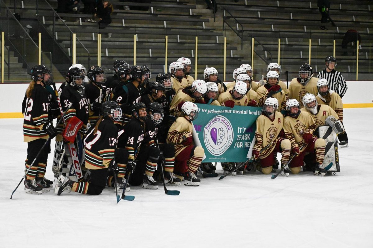 ATHLETES MENTAL HEALTH NIGHT. It was the hockey teams mental health awareness night, and the two opposing teams came together at the end of the game to stand together in unity in order to support athletes mental health. The banner features Sophies Squad, a program that assists athletes and brings awareness to players mental health throughout the year.