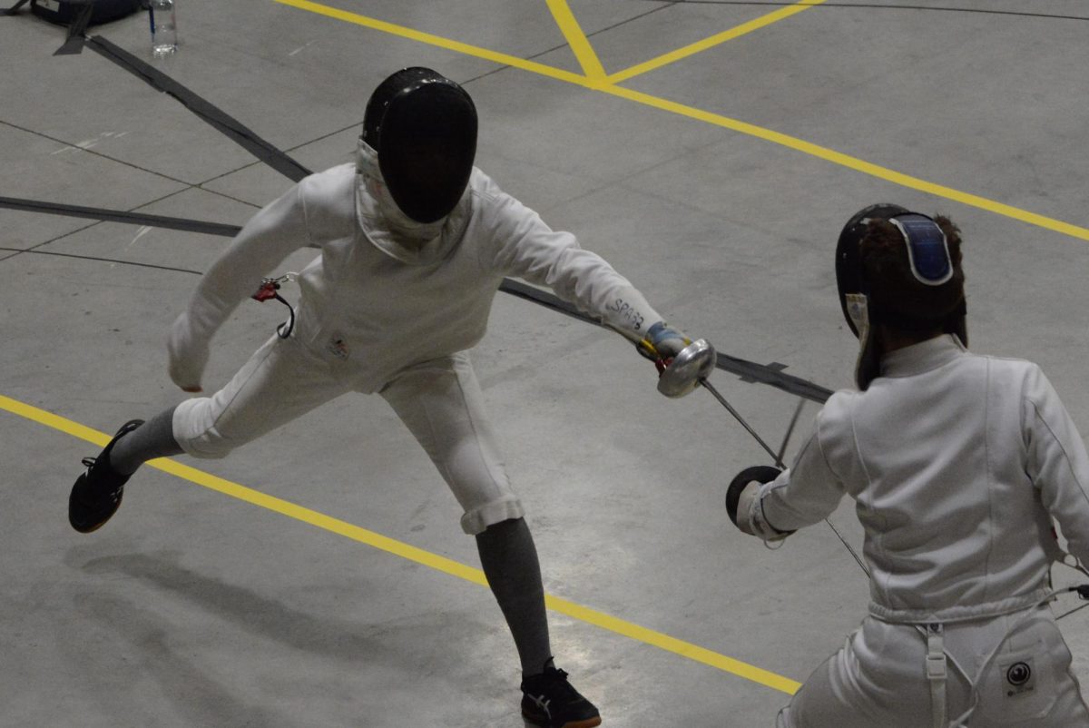 FLAWLESS FENCERS. Junior Belle Weng lunges at her competitor at a meet last season. New participants train to compete in meets, such as the one Belle was at in Rochester earlier this year.