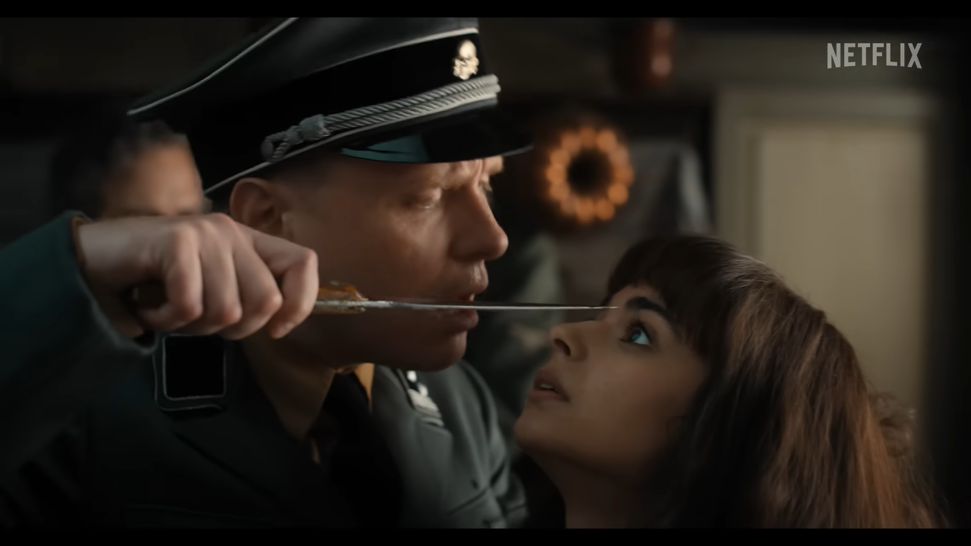 BROADCAST MUST GO ON. After a bomb lands on Marie-Laure Leblanc (Aria Mia Loberti)'s house where she broadcasts during WWII, she gets right back up and continues reading  her book in braille in order to send out important messages for the war.