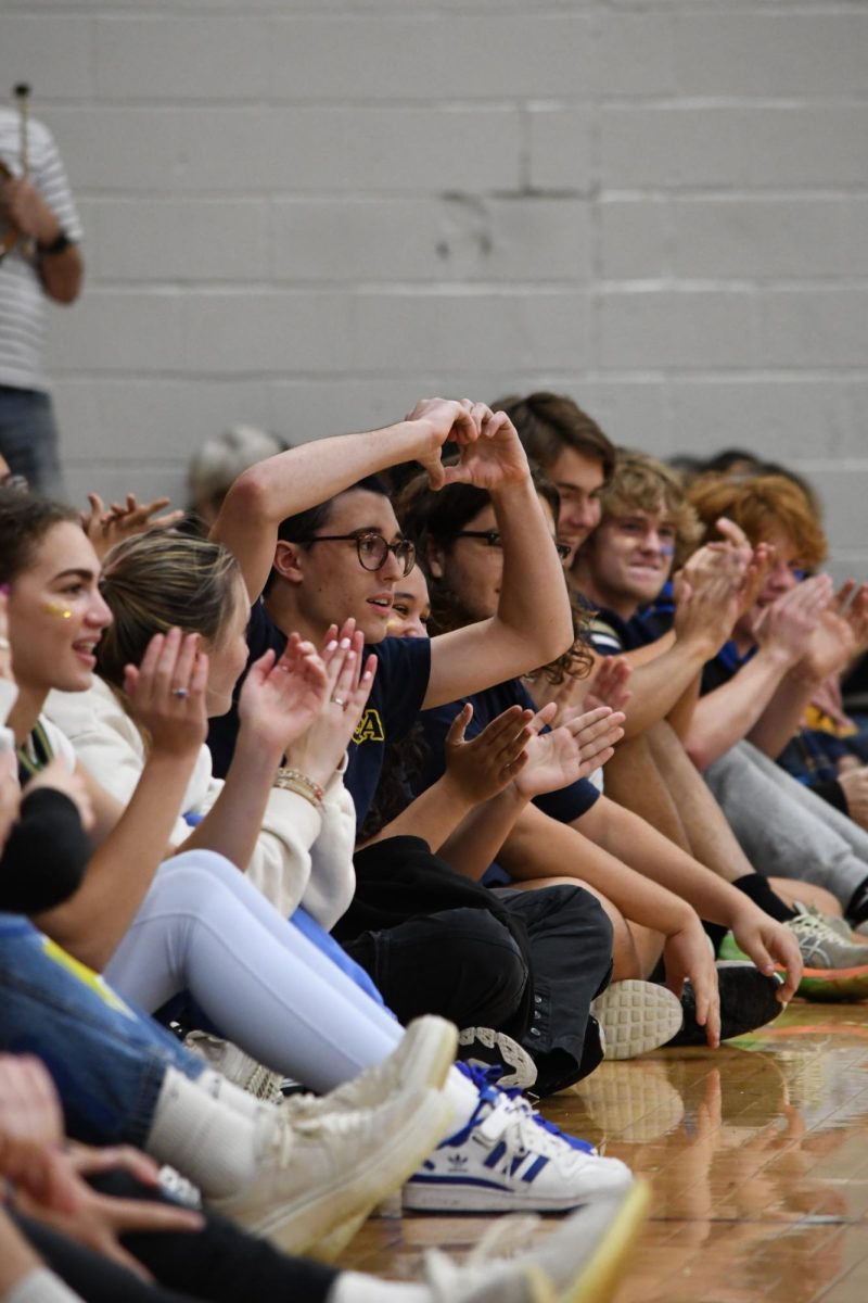 SPREAD LOVE. Senior Arden Lillemoe and the Class of 2024 cheered on their teammates during the relay race at the homecoming pep fest.