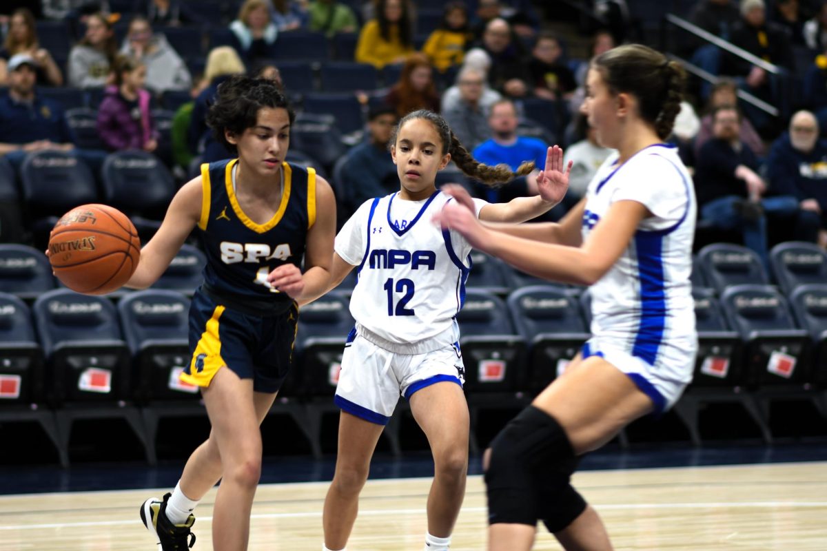 COURT OPERATOR: Sophomore Devyani Nelson takes the ball around two MPA players.