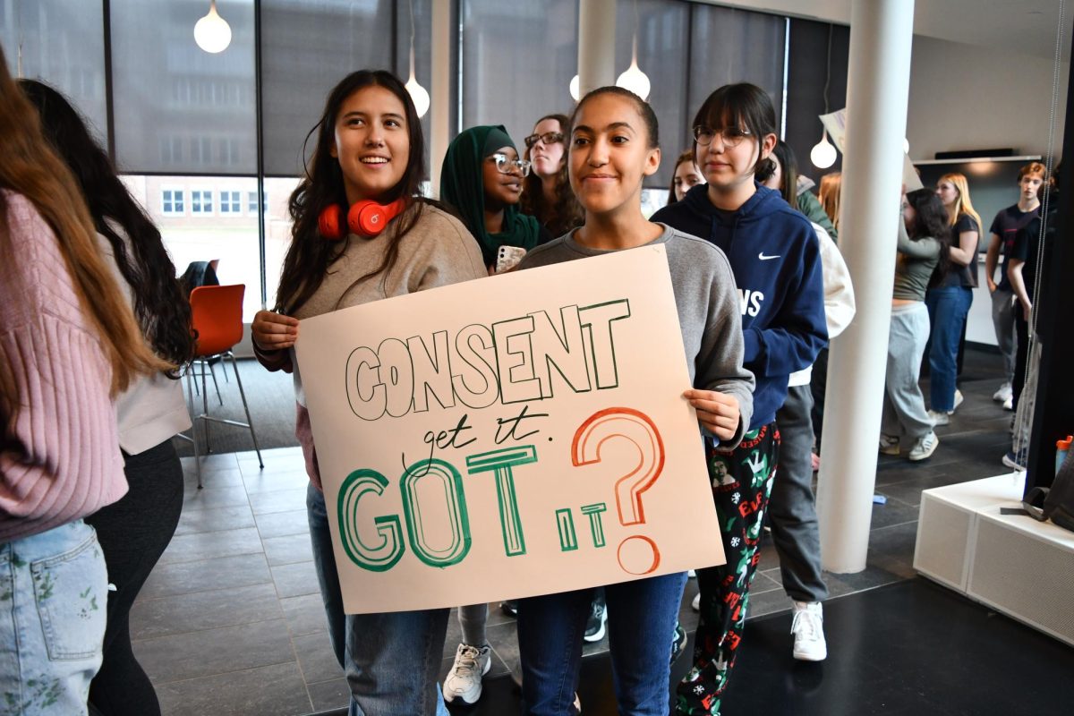 MARCH TO SUPPORT. Raven Glaser holds a sign promoting consent awareness during the march. 