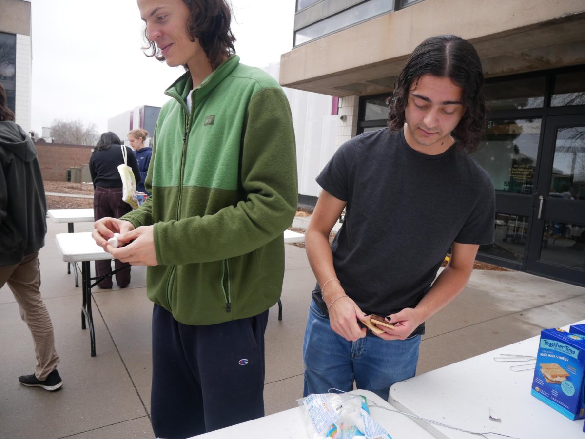 BUILDING THE SMORE. Juniors Oliver Thompson and Saurin Patel construct their smores during the Community Day activity block. Graham crackers, marshmallows, and chocolate were available for all. 