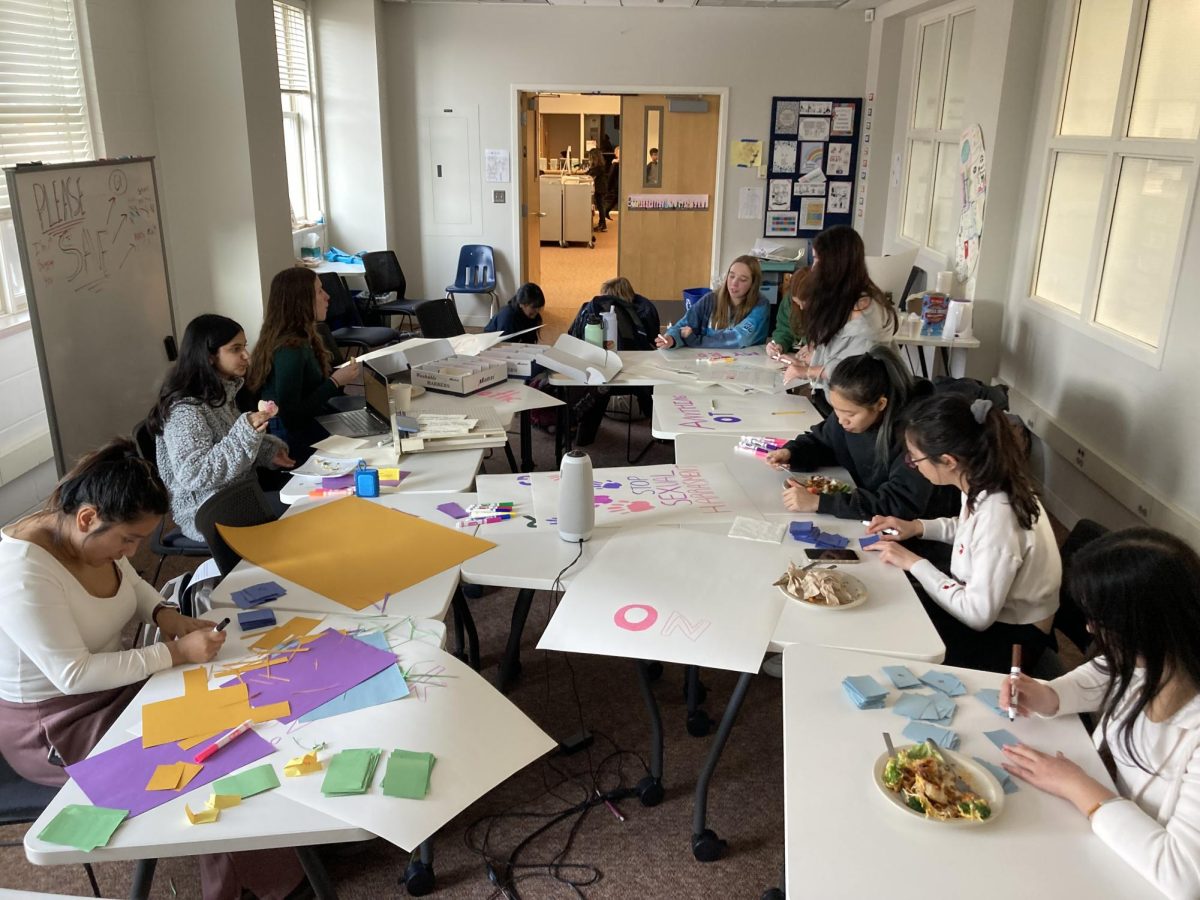 POSTERS AND LUNCH. Student of all grades, including assembly leaders Cerena Karmaliani, Naomi Kempcke, and Serene Kalugdan,  snack while finishing creating the materials used for community day. 