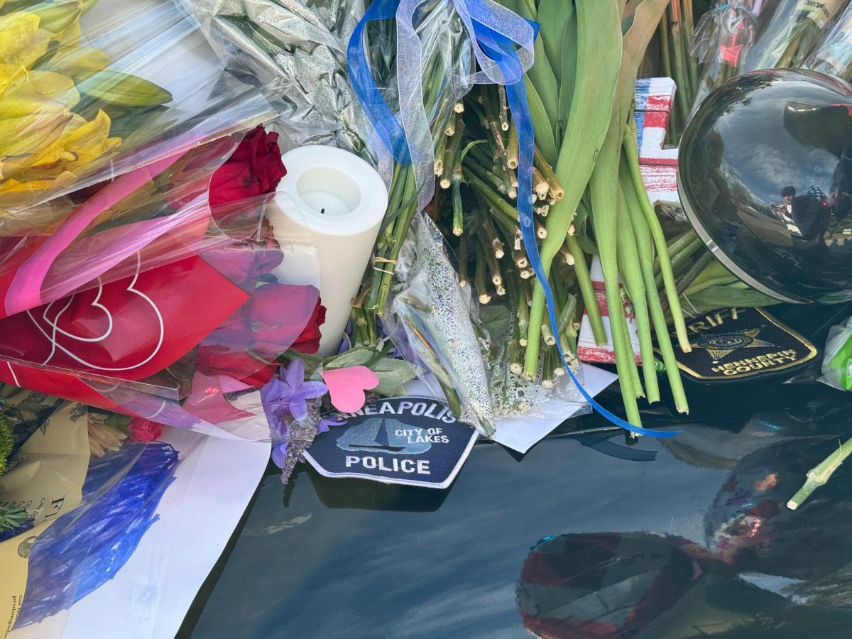 SERVE AND PROTECT. Badges from the Minneapolis Police Department and the Hennepin Country Sheriffs Department were placed on the patrol car of the fallen officers.