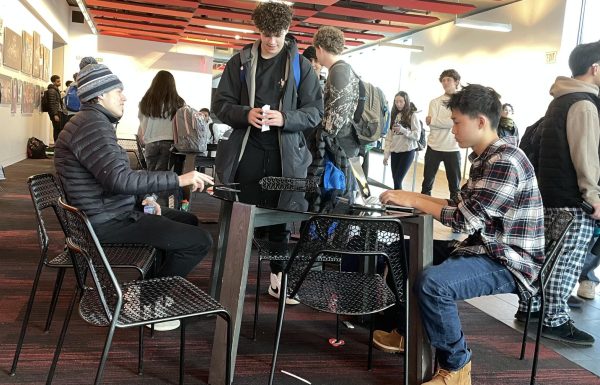 COUCH CONNECTIONS. A group of students talk after school at the new tables and chairs in Red Leaf Commons. The Huss couches were removed after winter break to create a more formal space. “We did not do the work to keep [the couches there,” said senior Poppy Ploen.