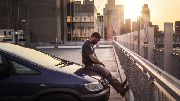 GRIEF: Dayo sits on his car thinking about memories. (The After press kit)