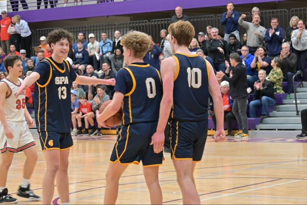 GOOD JOB. Captain Mikkel Rawdon goes in for a hug after freshman John Grimsrud makes his first basket of the game. “It felt good for this one to go in with everyone cheering” Grimsrud said. 
