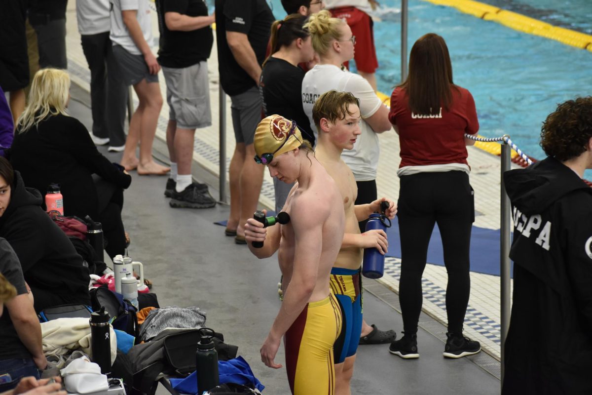 PRE-RACE PREP. Highland Park junior Jon Bailey-Zimmerman massages his muscles and senior Fred Myers hydrates before the big competition.