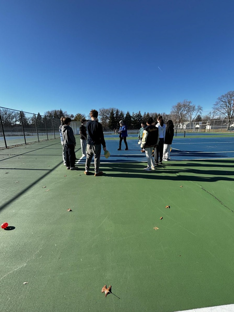 BACK OUTDOORS. The pickleball club stands outside in a circle as they play Spud, a strategic tag game played with pickleball balls and paddle, with the entire club. Club adviser Ben Bollinger Danielson said, “I love any opportunity to get students playing games. I like being outside and Pickleball is just a great activity.”