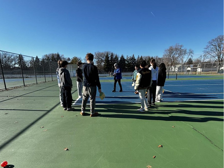 BACK OUTDOORS. The pickleball club stands outside in a circle as they play Spud, a strategic tag game played with pickleball balls and paddle, with the entire club. Club adviser Ben Bollinger Danielson said, “I love any opportunity to get students playing games. I like being outside and Pickleball is just a great activity.”