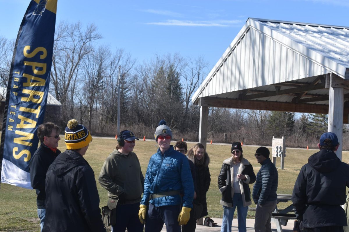 LAUGHING IT OFF. The trap team gathers with their parents and coaches between shooting rotations. After a full rotation, they meet up to listen to head coach John Rog read off their scores.