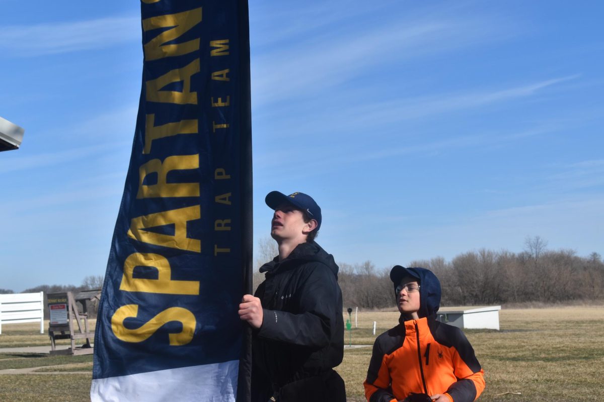 FLAGGED UP. Captain Johnny Rog and his brother Jeremiah hang up the Spartans team flag at the beginning of practice. 