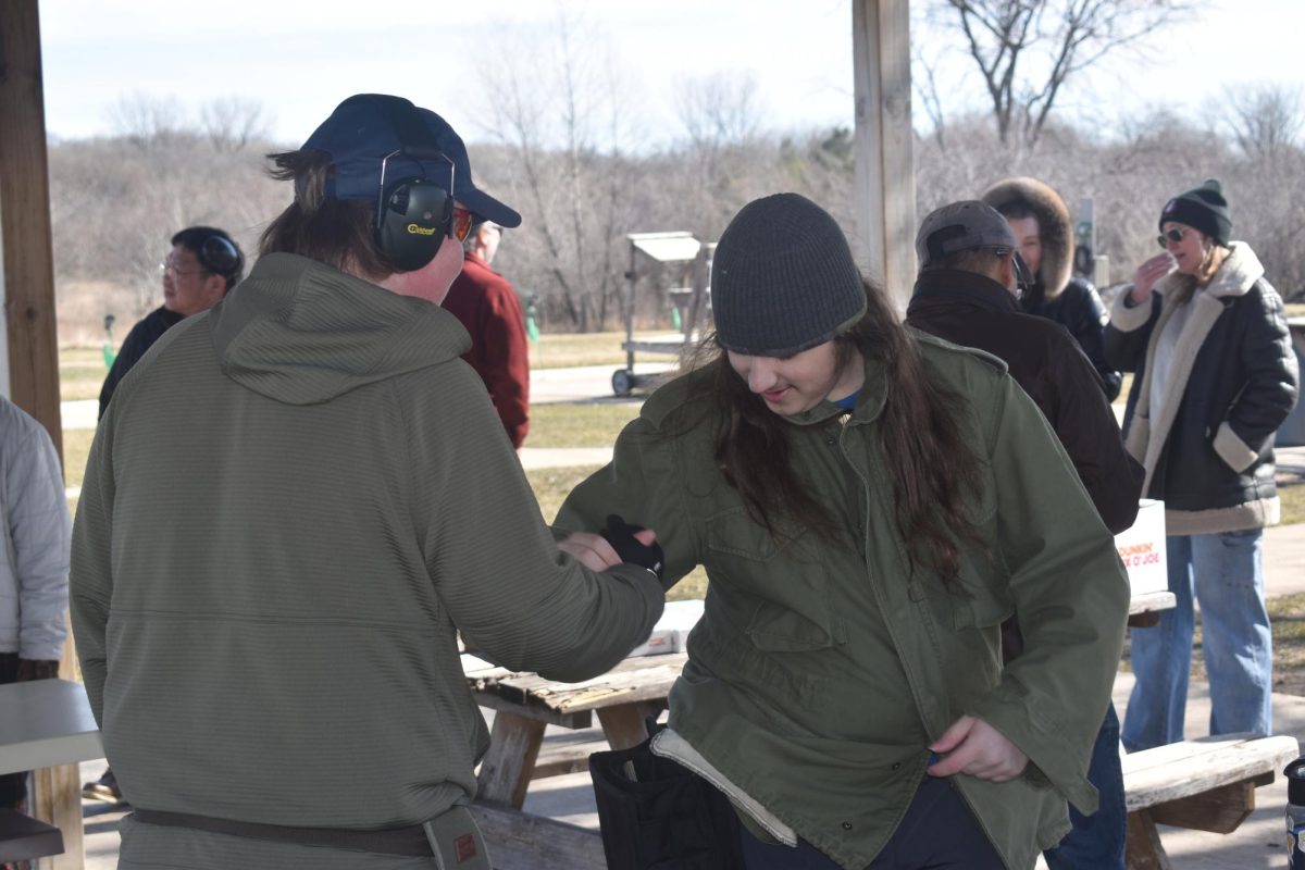 GET EXCITED. Freshman Axel Pearson (left), and captain Louis Fratzke (right) high-five each other while getting ready for their first shooting rotation of the day.
