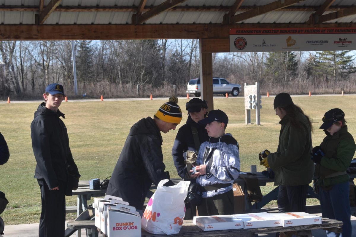 FUELING UP. The trap shooting team musters up before practice. Donuts and Coffee are a weekly tradition for the team’s early morning practices.