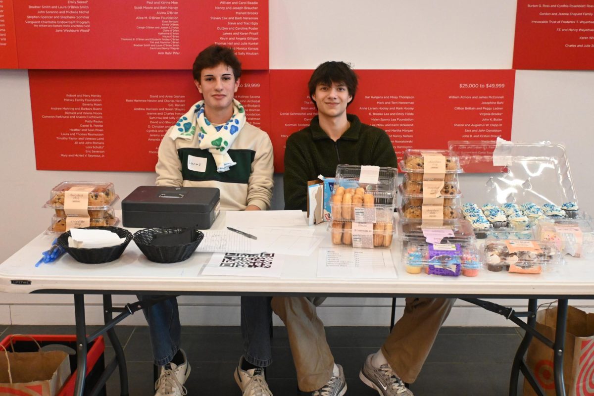 TIME FOR DESSERT. Club members Lucas Granja and Milan Mishra take a break while running the bake sale.