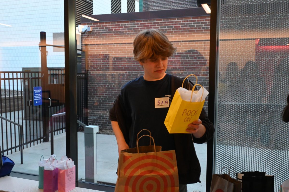 ROCK ON. Club member Sam Peterson inspects a bag spiced up with a rock-themed poem on the backside before adding more essential supplies -- period products, toiletries -- to it.
