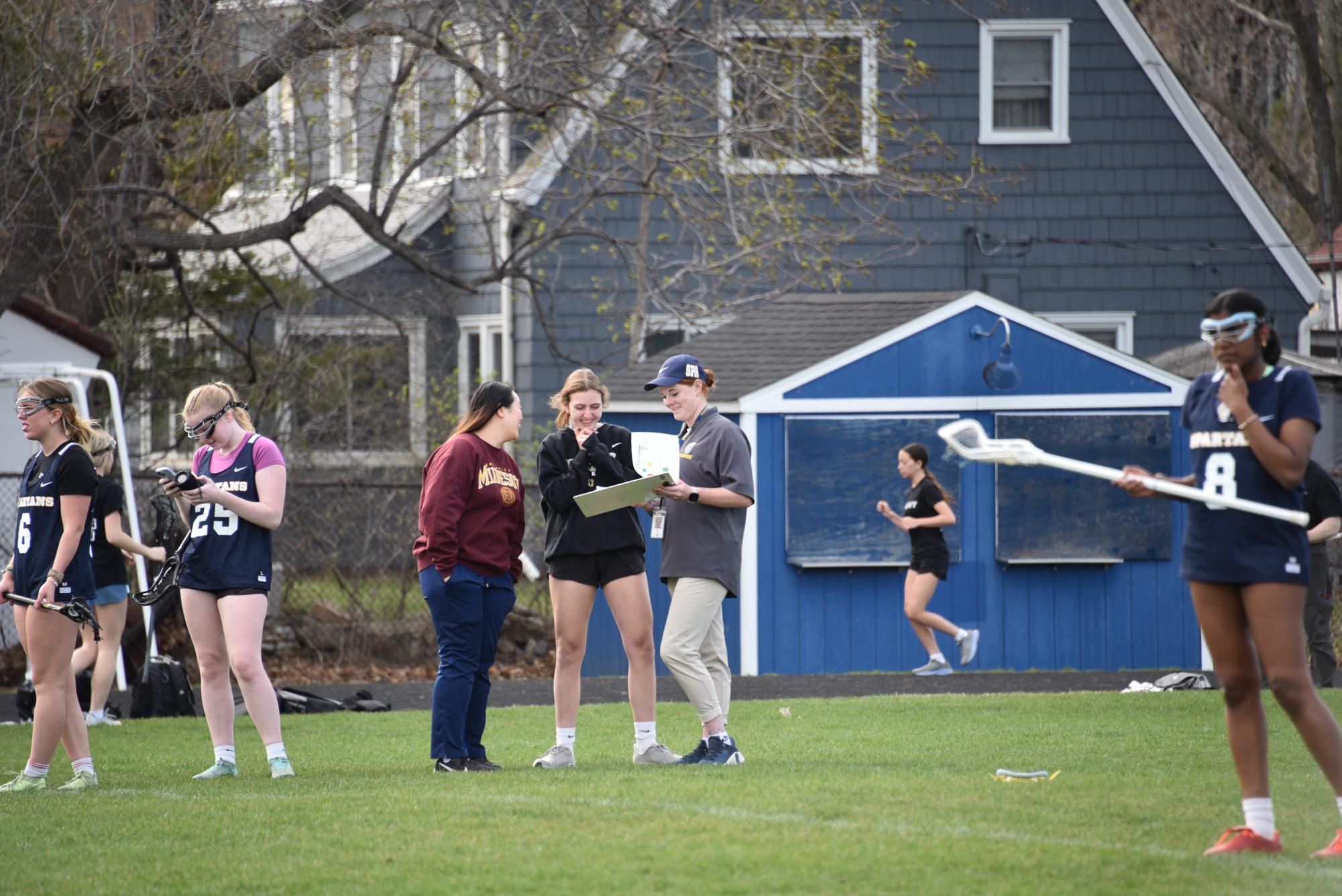 Captain Charlotte Goings, Taylor Tvedt, and Anna Boeser discuss practice plans.