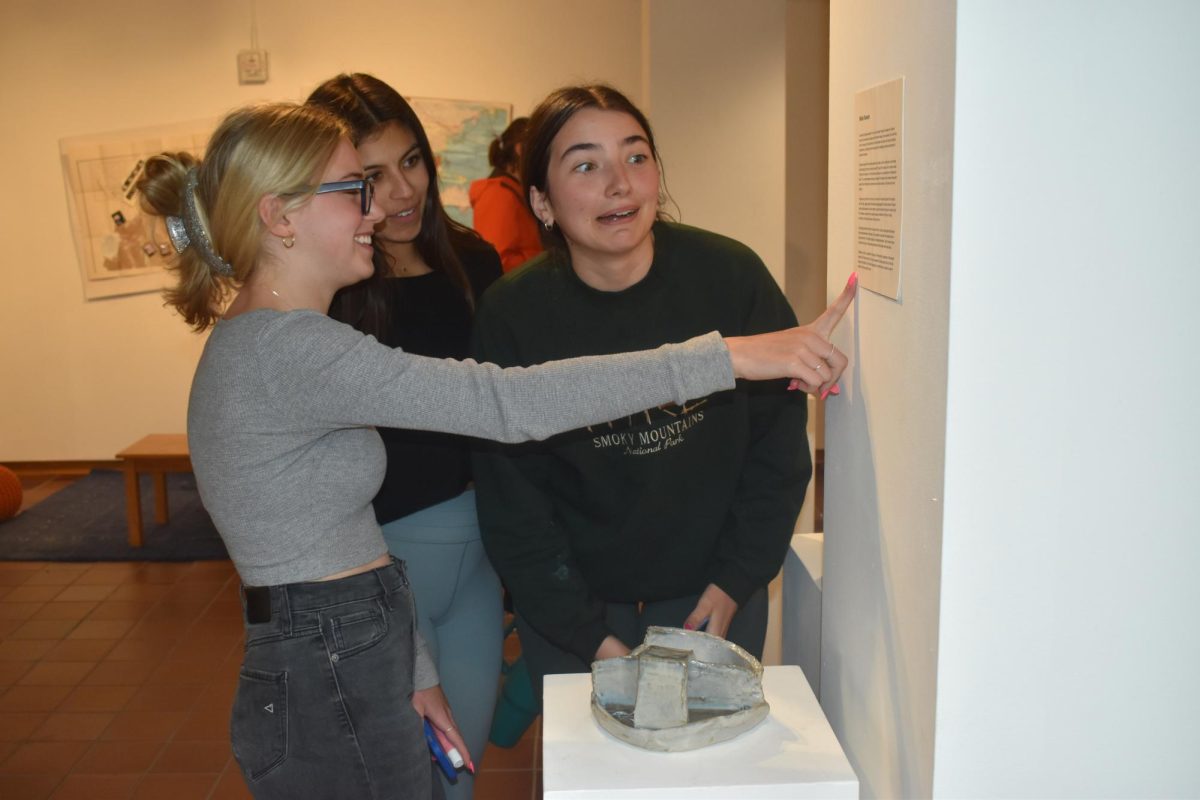 EXCELLENT EXHIBIT. Seniors Poppy Ploen, Aurelia Meza, and Annie Hlavka read a description featured in the exhibit.