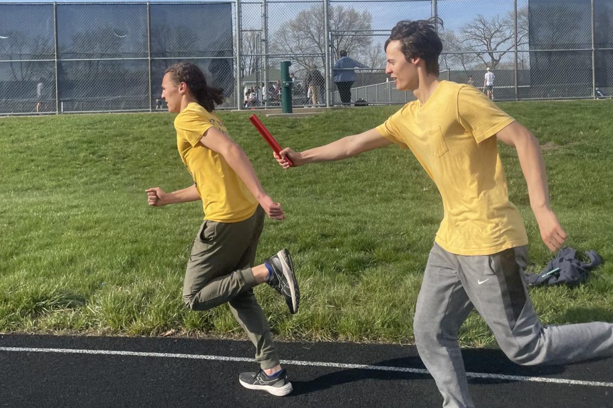 PRACTICE PARTNERS. Oliver Thompson passes the baton to his younger brother Langston at a track practice. The siblings have been on the track and basketball teams together. “I give him more direction than other people,” Oliver said. 