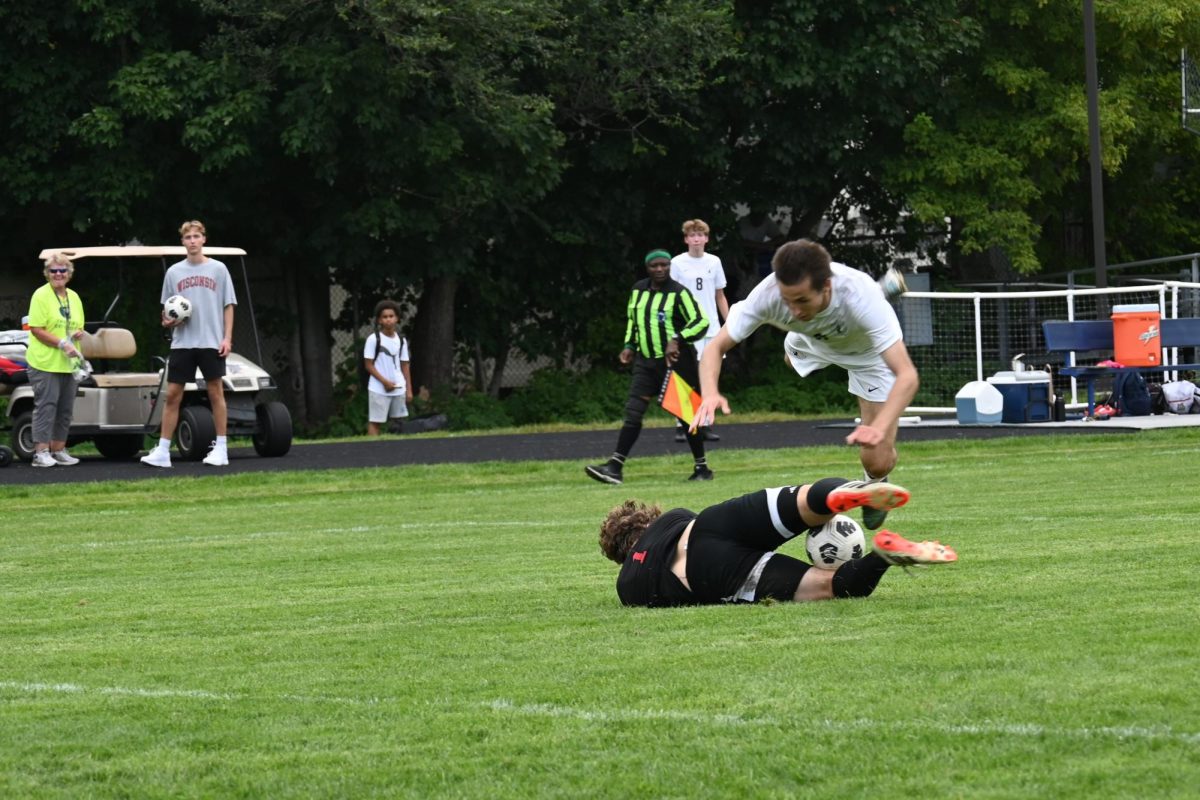 FLYING. The Scots Goalie drops to the ground, blocking the ball and painfully tripping senior Finn Sullivan by his shins.