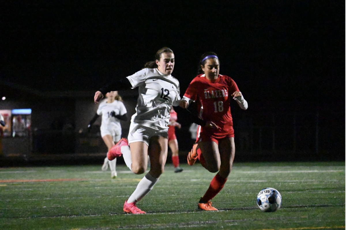 GAME FACE. Clare Ryan-Bradley fights for a ball in a one-on-one, pushing towards goal. Ryan-Bradley was able to beat both the defender and the keeper to the ball, poking it past into the back of the net, giving the Spartans a 1-0 lead. This goal put the Spartans up early in their first chance of the game, a near perfect mirror of the beginning of the section semifinal.