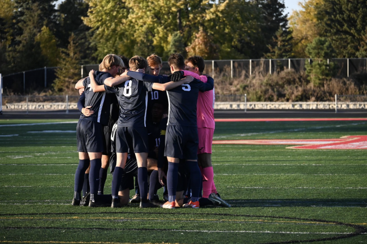 PREGAME PREP. BVS starters huddle around the captains before the game begins. A boy’s soccer tradition, the captains chant and the rest of the team calls out in response in a sort of battle cry before every game.
