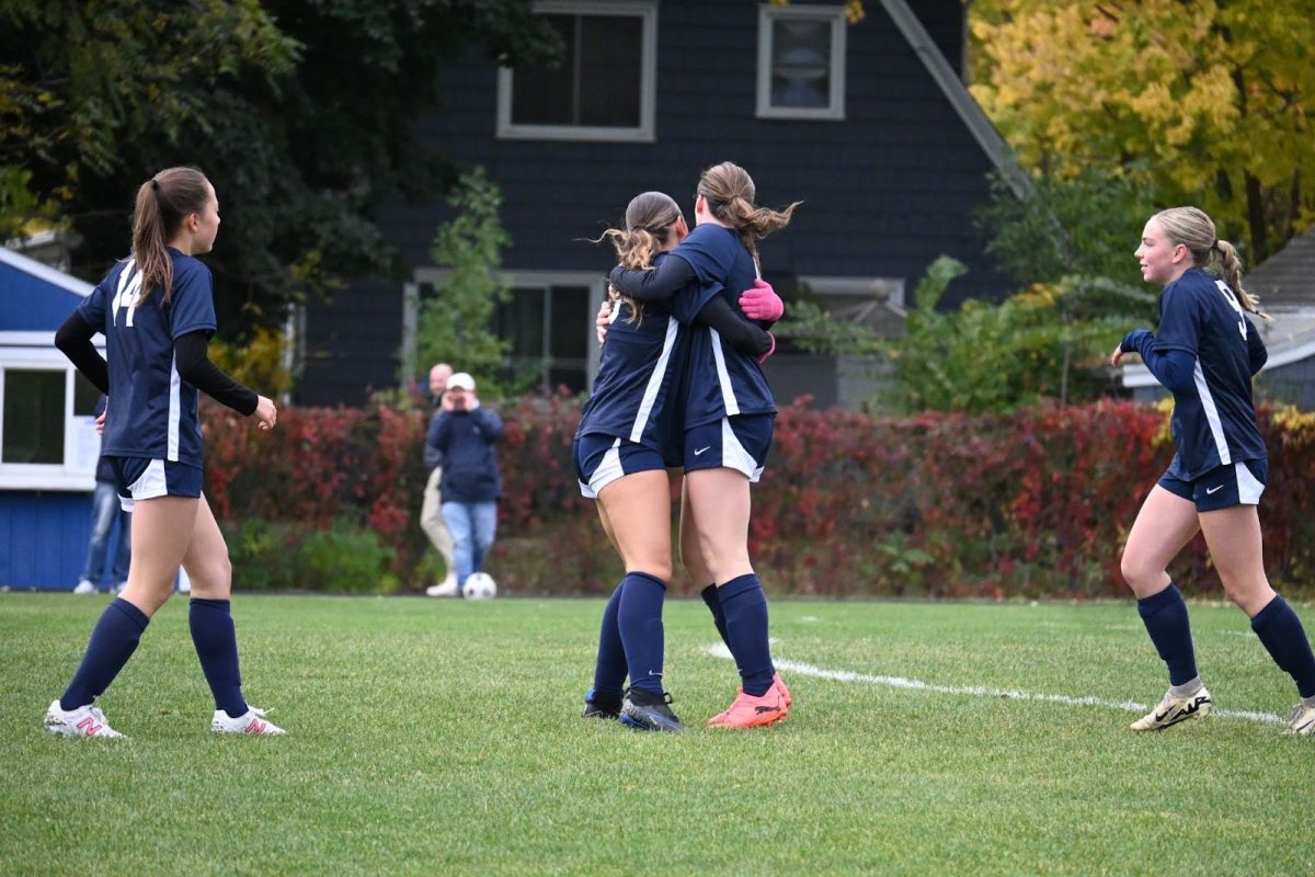 TEAM TRIUMPH. Captain Lucia Gonzales=z (‘26) embraces Clare Ryan-Bradley (‘26) in celebration of Ryan-Bradley’s goal as they run back to half field. 
