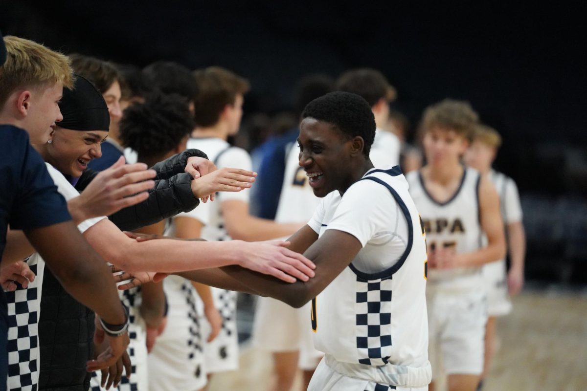 CELEBRATE. Junior LaRon Johnson celebrates his three pointer with his team after the game ends.