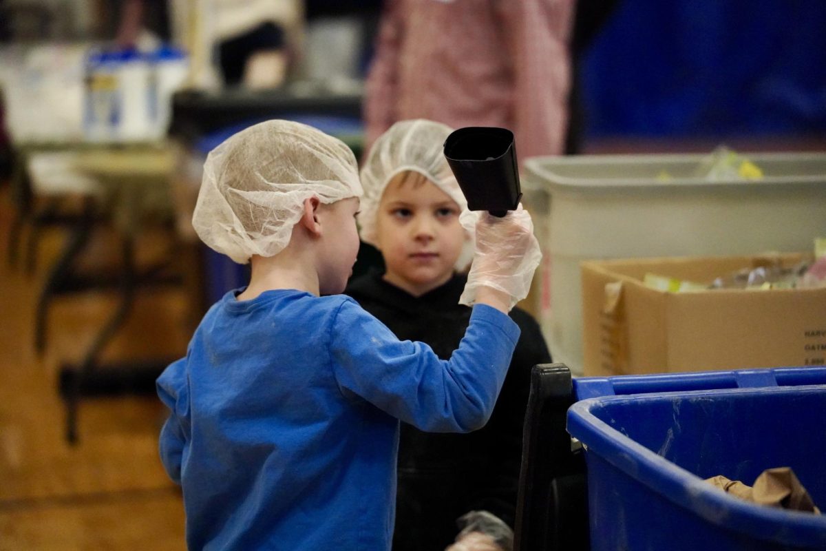 RING THAT BELL. Students ring the bell to signal their table has completed packaging a box containing 40 bags of food.