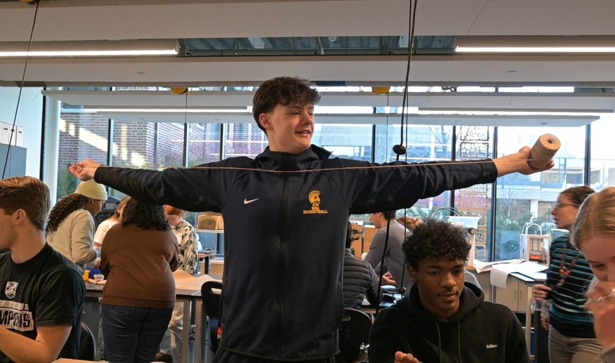 MEASURING IT OUT. Senior Nathan Rock tries to determine how much twine he needs for his next star.