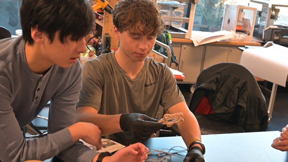 SHINE BRIGHT. Seniors Theo Su and Caden Burns measure twine and wrapped sticks to create ornaments for STAR HOUSE.